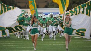 high school football and cheerleaders running